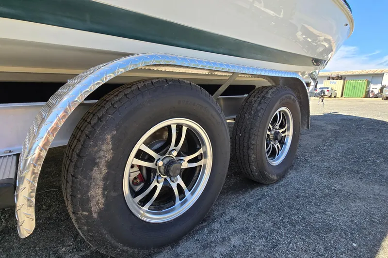 Slide: The Image of Trailer wheels of a 1996 Cobalt 220 boat on gravel surface. - 12