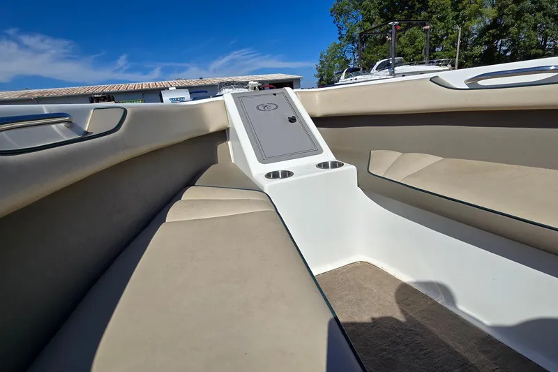 Slide: The Image of 1996 Cobalt 220 boat interior with beige seating and cup holders under a clear blue sky. - 14