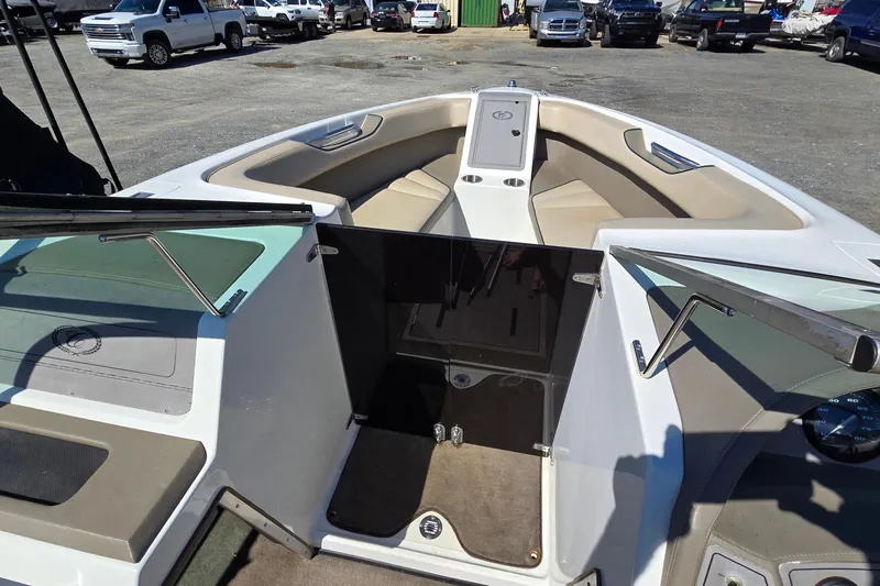 Slide: The Image of 1996 Cobalt 220 boat interior with beige seating and open windshield, parked in a lot. - 17