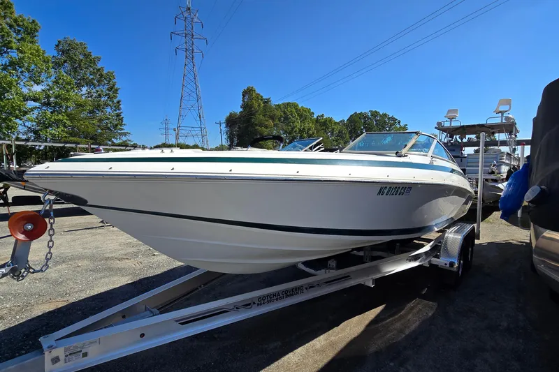 Slide: The Image of 1996 Cobalt 220 boat on trailer, parked outdoors under clear blue sky. - 3