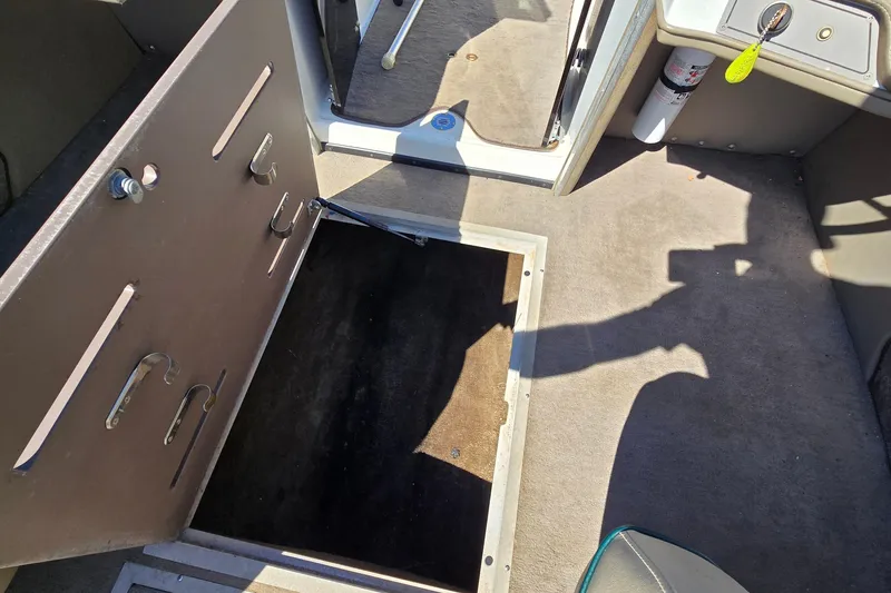 Slide: The Image of Interior of a 1996 Cobalt 220 boat showing storage compartment and carpeted floor. - 33