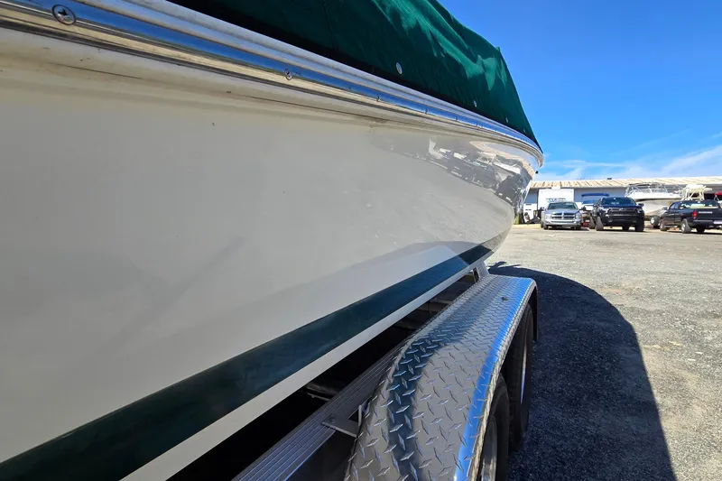 Slide: The Image of 1996 Cobalt 220 boat on trailer, side view with green cover, parked outdoors. - 4