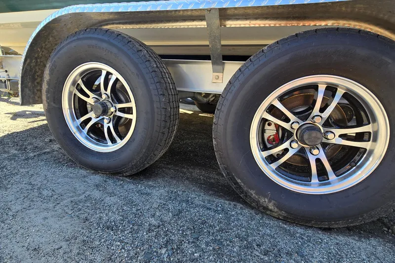 Slide: The Image of Trailer wheels with chrome rims on a 1996 Cobalt 220 boat trailer. - 41