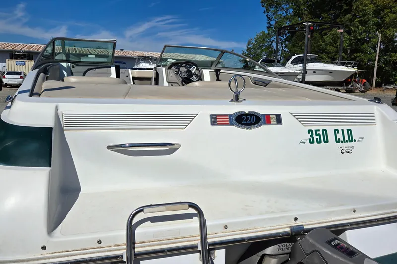 Slide: The Image of 1996 Cobalt 220 boat with 350 C.I.D. engine, parked outdoors under blue sky. - 5