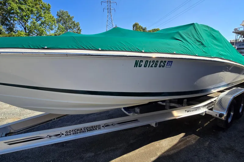 Slide: The Image of 1996 Cobalt 220 boat with green cover on trailer, parked outdoors. - 7