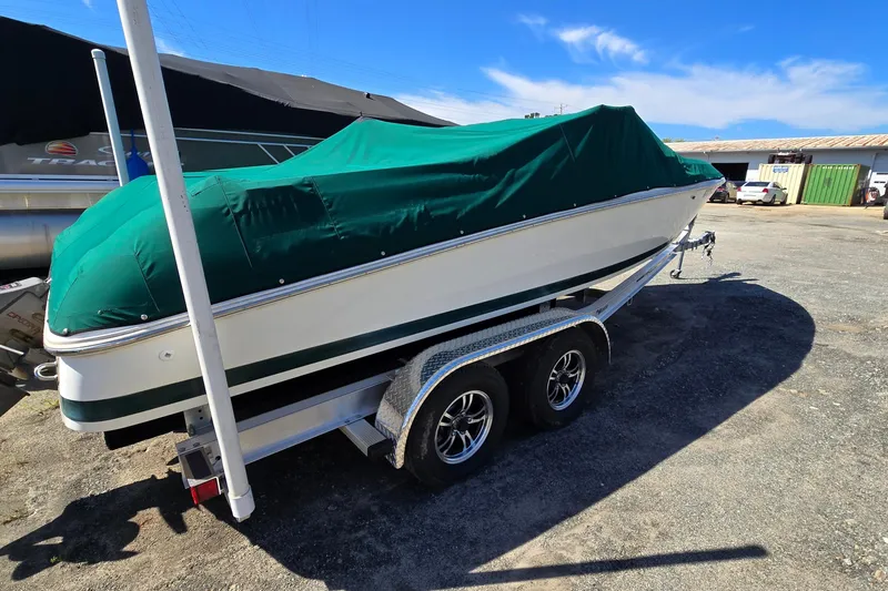 Slide: The Image of Covered 1996 Cobalt 220 boat on trailer, parked outdoors under clear blue sky. - 8
