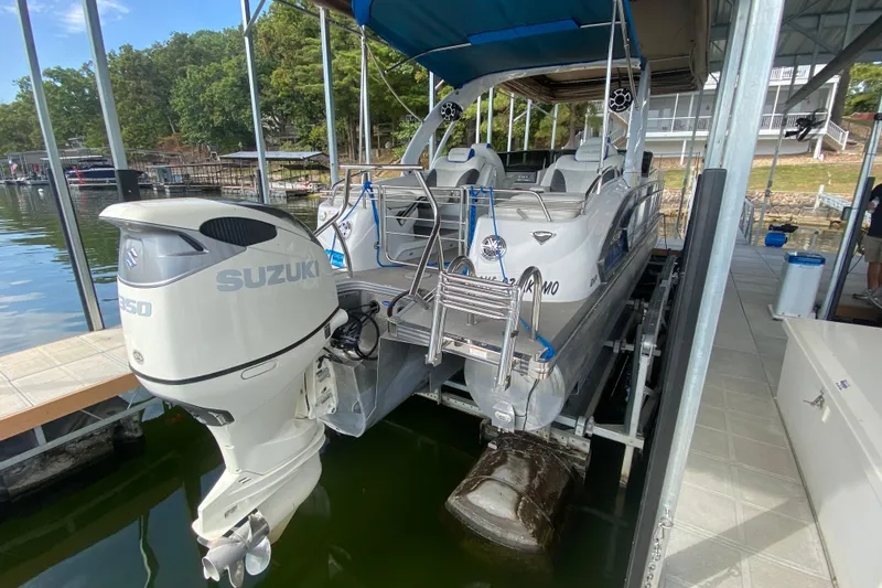 Slide: The Image of 2018 Manitou 25 X-Plode SRW SHP pontoon boat with Suzuki outboard motor on a lift. - 13