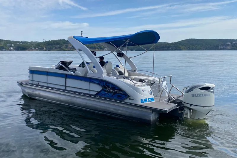 Slide: The Image of 2018 Manitou 25 X-Plode SRW SHP pontoon boat with blue canopy on a lake. - 3