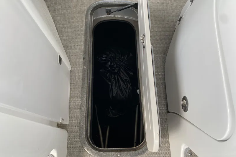 Slide: The Image of Open storage compartment on 2018 Manitou 25 X-Plode SRW SHP boat, showing interior space. - 37