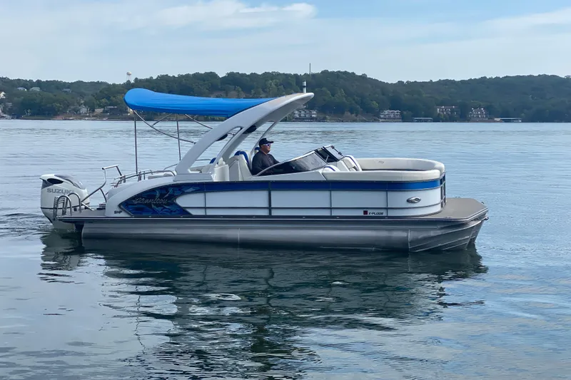 Slide: The Image of 2018 Manitou 25 X-Plode SRW SHP pontoon boat on a calm lake. - 6