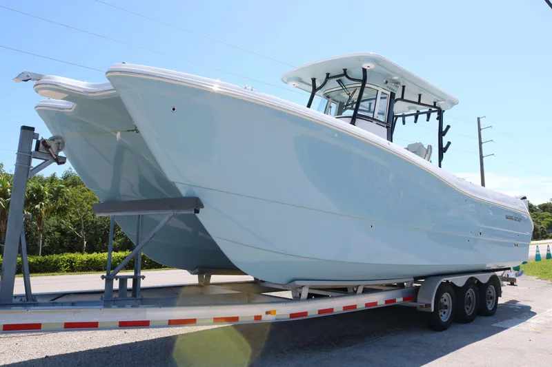 The Image of 2026 World Cat 295 CC boat on trailer, sleek design, clear sky background. - 0