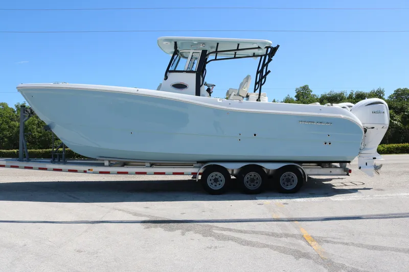 Slide: The Image of 2026 World Cat 295 CC boat on trailer, side view, clear sky background. - 1