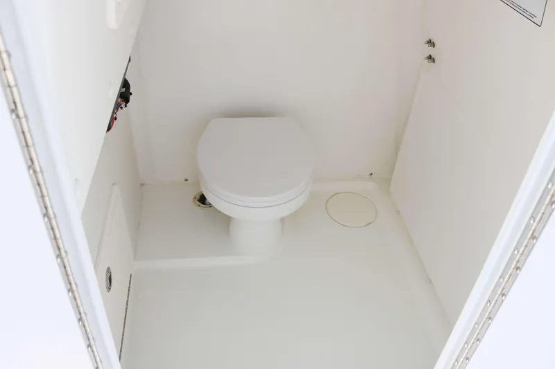 Slide: The Image of Interior of 2026 World Cat 295 CC boat featuring a compact marine toilet. - 11