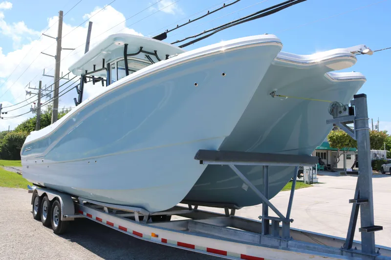 Slide: The Image of 2026 World Cat 295 CC boat with twin Yamaha engines on a trailer. - 2