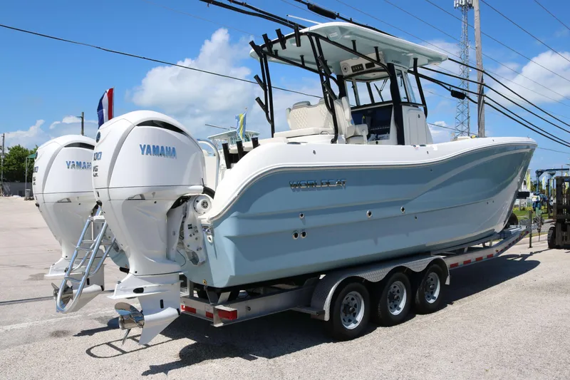 Slide: The Image of 2026 World Cat 295 CC boat on trailer, parked outdoors under clear sky. - 3