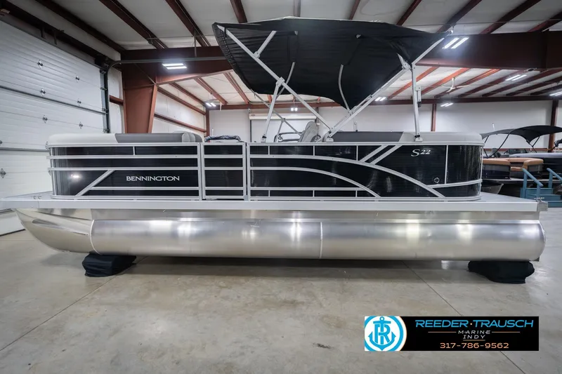 Slide: The Image of 2026 Bennington 22 SSR pontoon boat in showroom, featuring sleek design and canopy. - 11
