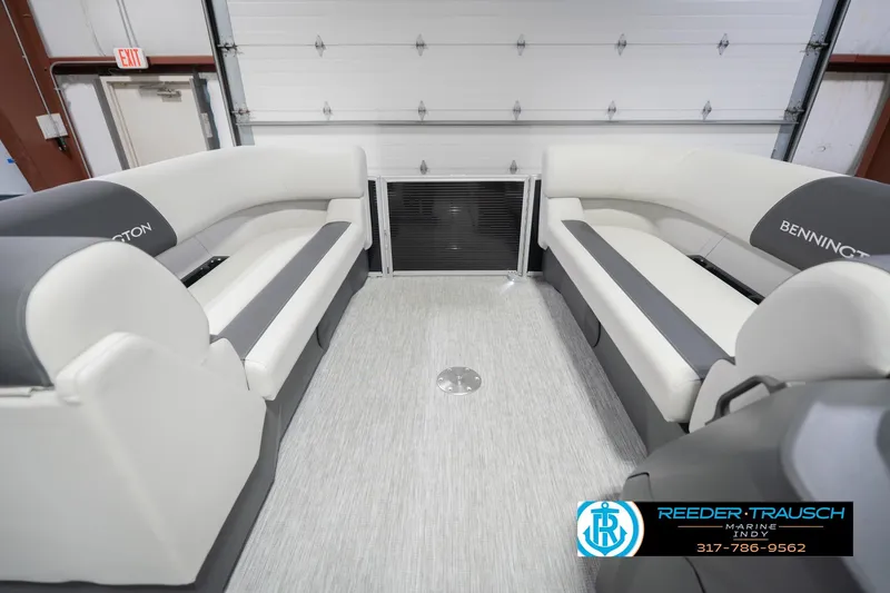 Slide: The Image of 2026 Bennington 22 SSR pontoon boat interior with plush seating in a showroom. - 22