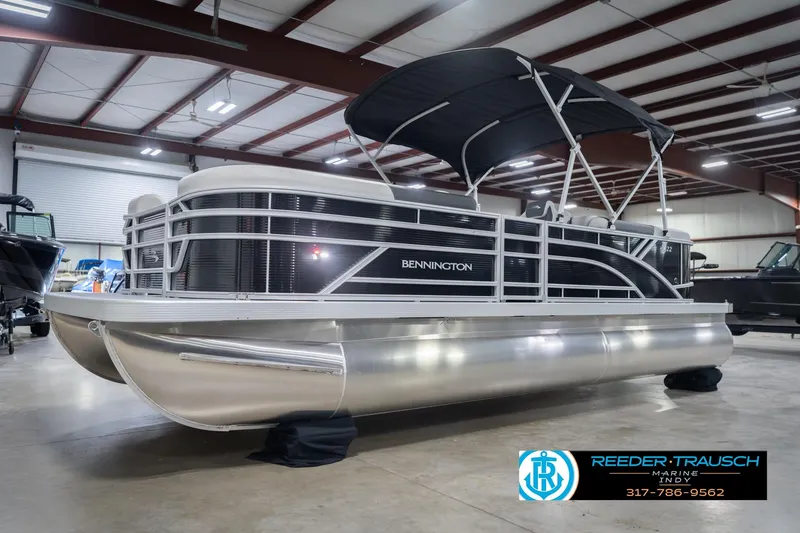 Slide: The Image of 2026 Bennington 22 SSR pontoon boat in showroom with canopy and sleek design. - 4