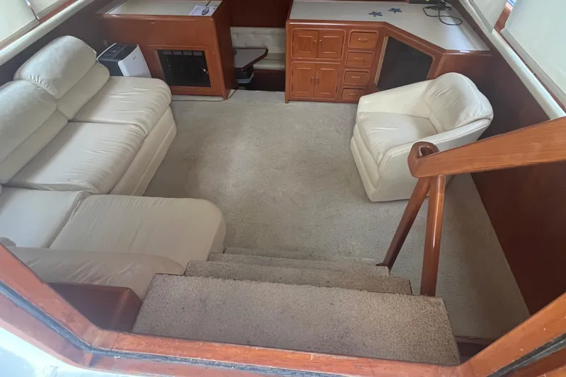 Slide: The Image of 1990 Pace 42 Motor Yacht interior with beige seating, wooden cabinetry, and carpeted flooring. - 14