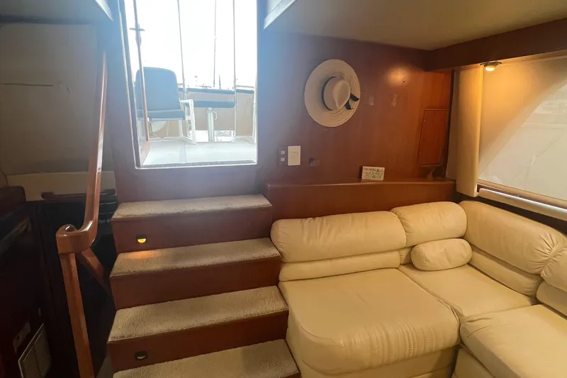 Slide: The Image of Interior of 1990 Pace 42 Motor Yacht with white leather seating and wooden stairs. - 15