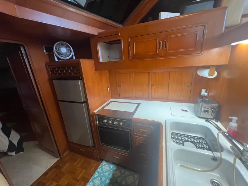 Slide: The Image of 1990 Pace 42 Motor Yacht kitchen with wood cabinetry, stove, sink, and refrigerator. - 20