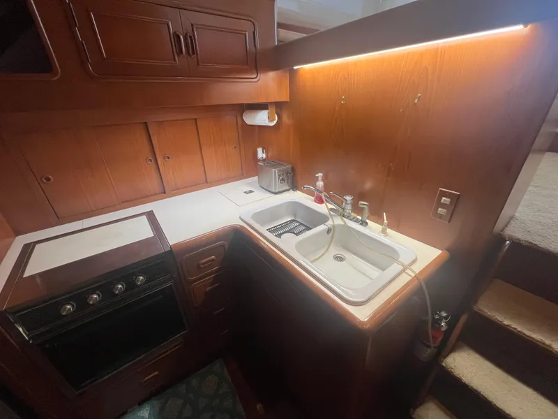 Slide: The Image of 1990 Pace 42 Motor Yacht kitchen with wooden cabinetry, sink, and stove. - 21