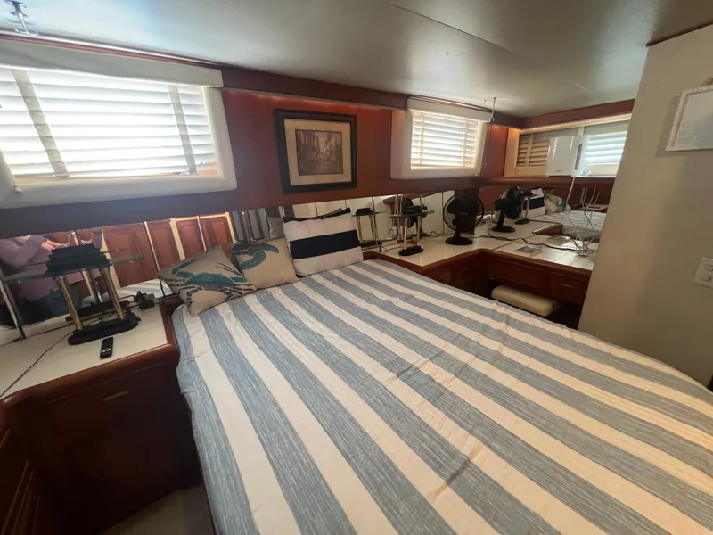 Slide: The Image of Cozy bedroom in 1990 Pace 42 Motor Yacht with striped bedding and wooden accents. - 27