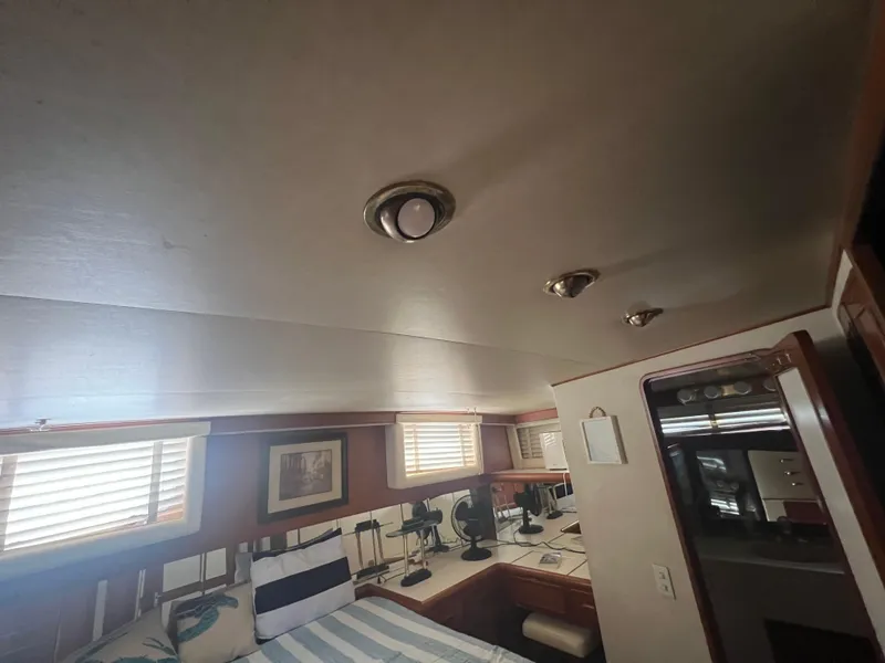 Slide: The Image of 1990 Pace 42 Motor Yacht interior with bed, windows, and desk area. - 28