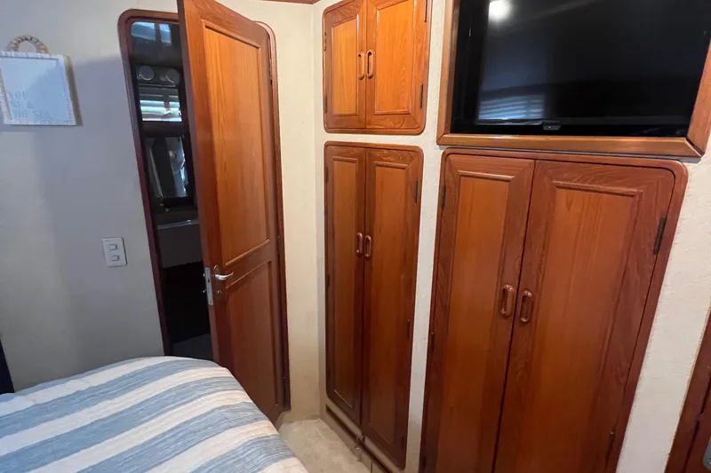 Slide: The Image of Interior of 1990 Pace 42 Motor Yacht with wooden cabinets and mounted TV. - 29