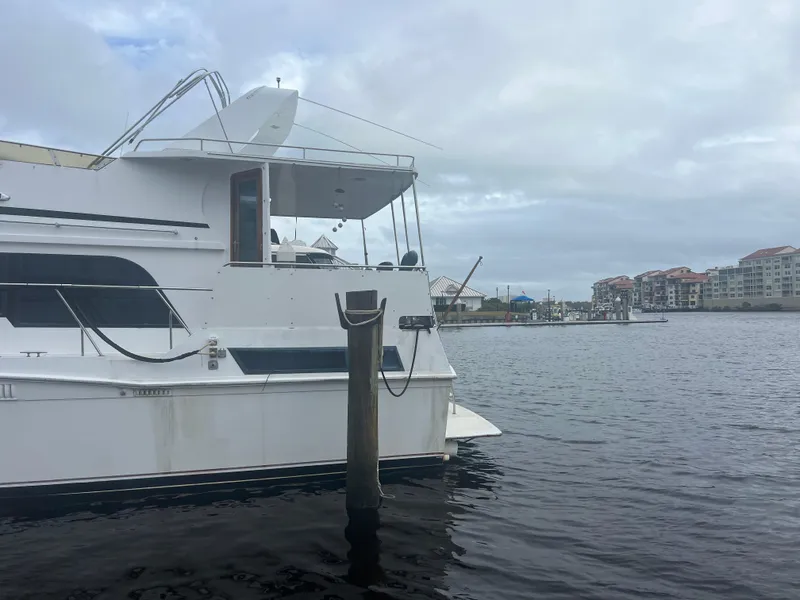 Slide: The Image of 1990 Pace 42 Motor Yacht docked at marina with cloudy sky backdrop. - 3