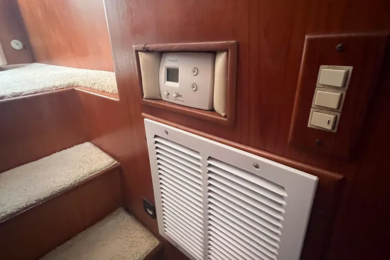 Slide: The Image of Interior of 1990 Pace 42 Motor Yacht with thermostat and vent near carpeted stairs. - 31