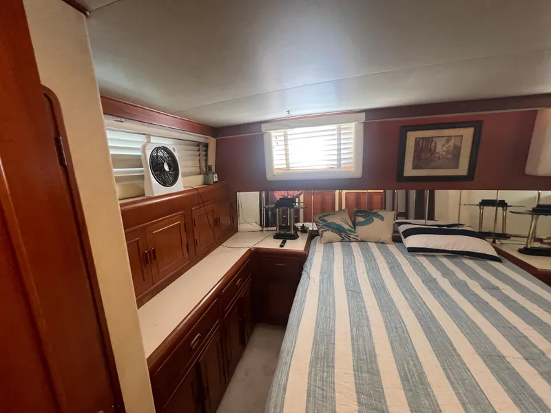 Slide: The Image of Cozy bedroom in 1990 Pace 42 Motor Yacht with striped bedding and wooden cabinetry. - 32