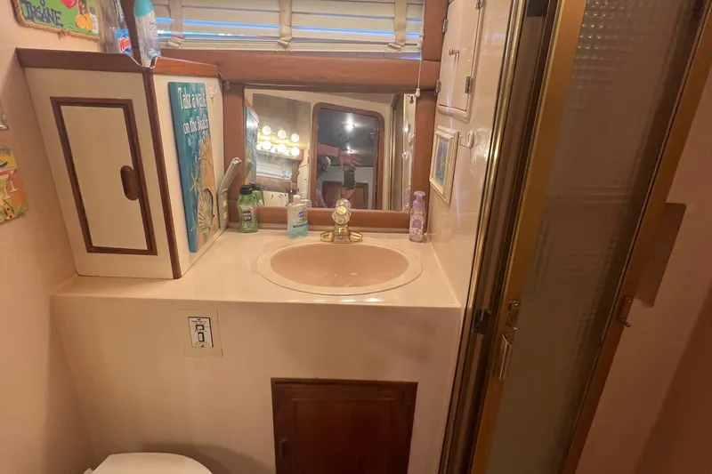 Slide: The Image of 1990 Pace 42 Motor Yacht bathroom with sink, mirror, and storage cabinets. - 35