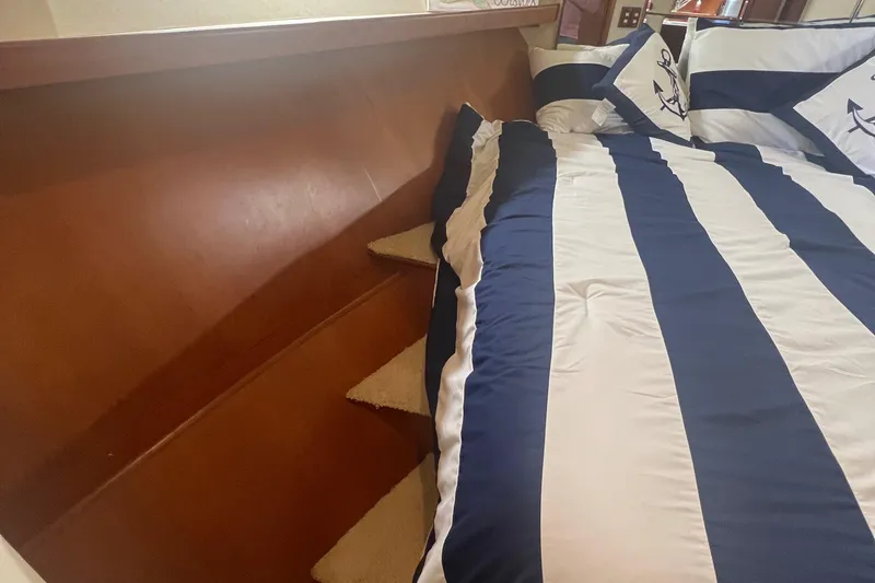 Slide: The Image of 1990 Pace 42 Motor Yacht interior with striped bedding and wooden paneling. - 40