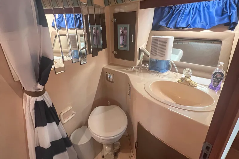 Slide: The Image of Bathroom interior of 1990 Pace 42 Motor Yacht with sink, toilet, and striped curtain. - 41