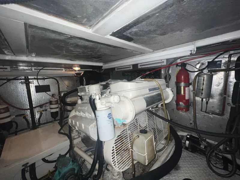 Slide: The Image of Engine room of a 1990 Pace 42 Motor Yacht, featuring mechanical components and fire extinguisher. - 44