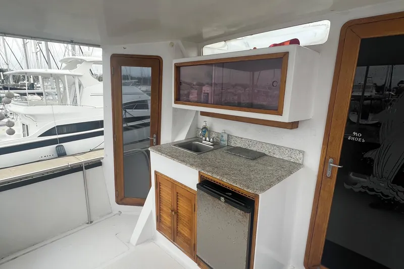Slide: The Image of 1990 Pace 42 Motor Yacht interior with kitchenette, featuring sink, countertop, and storage cabinets. - 8