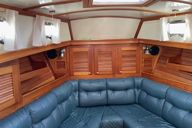 Slide: The Image of Interior of 2000 Gozzard 37 sailboat with blue seating and wooden cabinetry. - 15