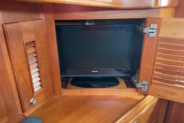 Slide: The Image of Cabinet with TV inside Gozzard 37 yacht, 2000 model, featuring wooden interior. - 22