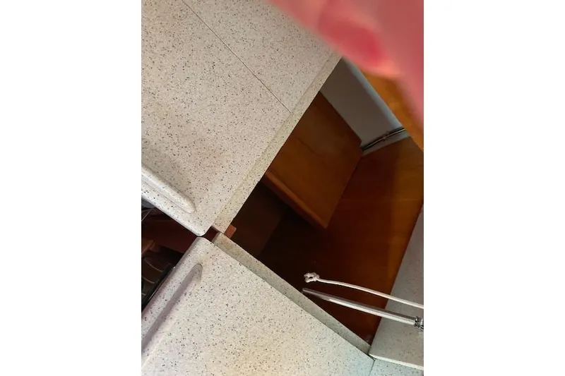 Slide: The Image of Interior view of a 2000 Gozzard 37 sailboat kitchen with speckled countertops. - 27