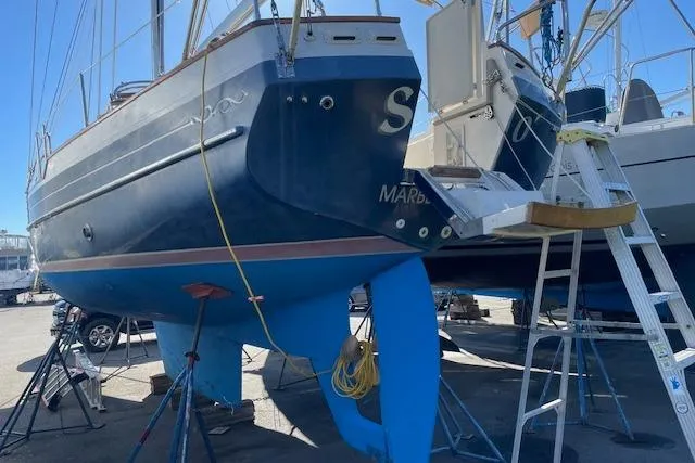 Slide: The Image of Gozzard 37 sailboat from 2000 on dry dock, blue hull, ladder access. - 9