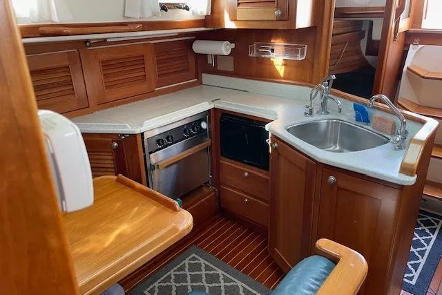 Slide: The Image of Gozzard 37 yacht interior kitchen with wood cabinetry, stove, and sink, year 2000 model. - 18