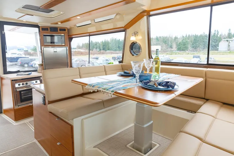 Slide: The Image of Manufacturer Provided Image: Luxurious interior of 2025 Ranger Tugs R-43 CB with dining area and modern kitchen. - 11