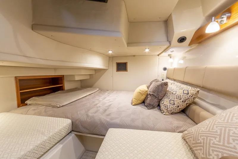 Slide: The Image of Manufacturer Provided Image: Cozy cabin interior of 2025 Ranger Tugs R-43 CB with plush bedding and ambient lighting. - 13