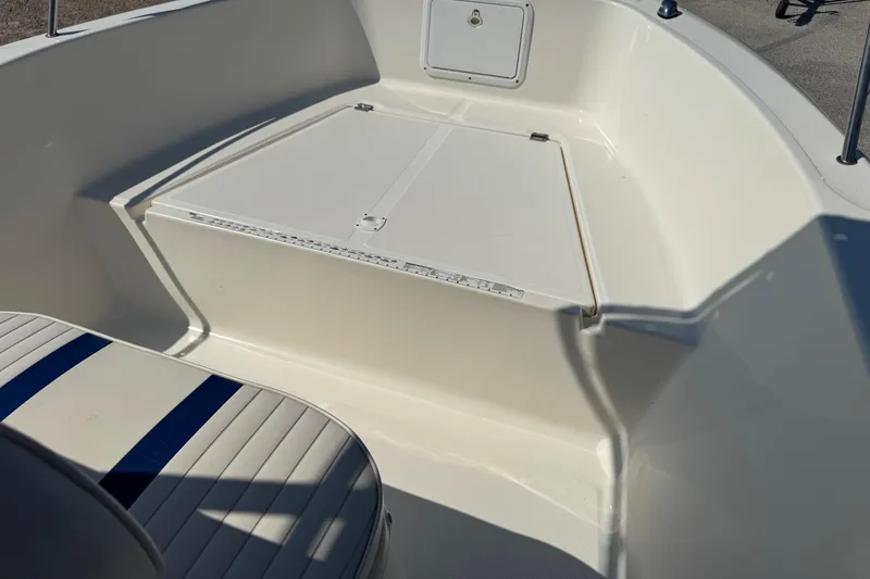 Slide: The Image of 2002 Sea Fox 236 Center Console boat interior with seating and storage compartment. - 11