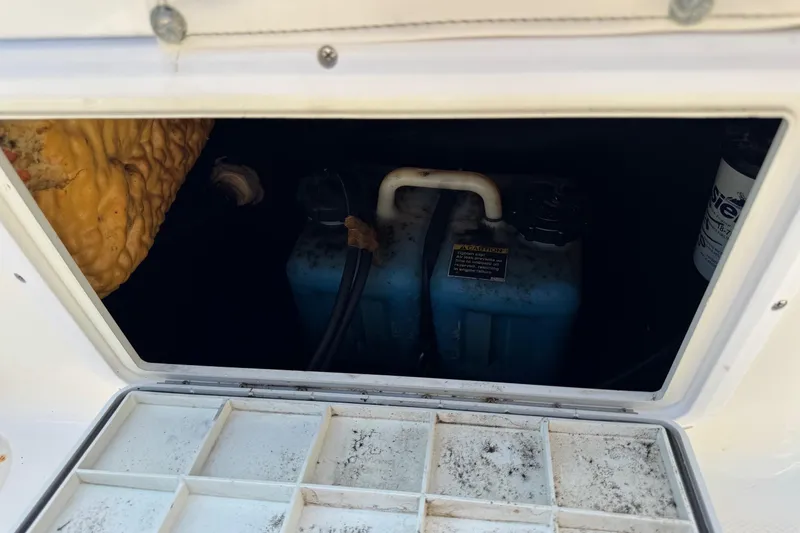 Slide: The Image of Storage compartment of a 2002 Sea Fox 236 Center Console boat, showing blue containers. - 30