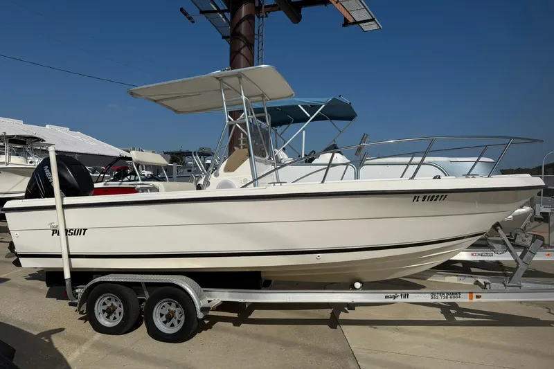 The Image of 1994 Pursuit 2150 Dual Console boat on trailer, side view, sunny day. - 0