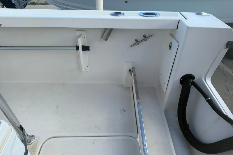 Slide: The Image of 1994 Pursuit 2150 Dual Console boat interior, featuring storage compartments and rod holders. - 10