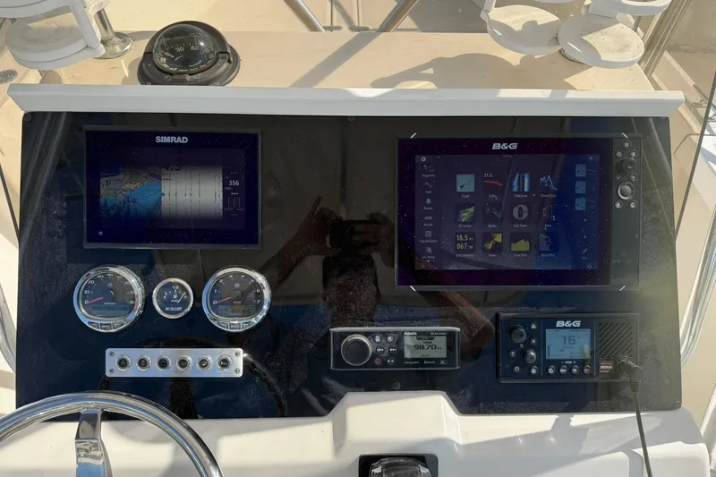 Slide: The Image of 1994 Pursuit 2150 Dual Console dashboard with Simrad and B&G navigation displays. - 14