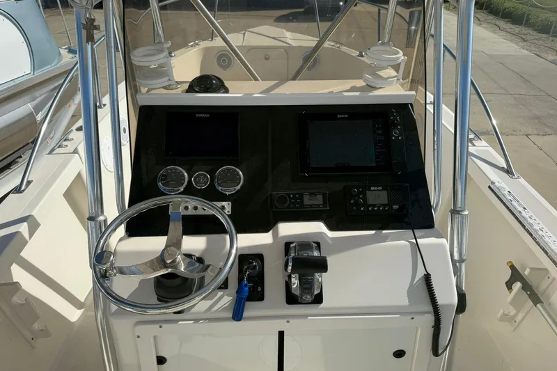 Slide: The Image of 1994 Pursuit 2150 Dual Console boat dashboard with steering wheel and navigation controls. - 16
